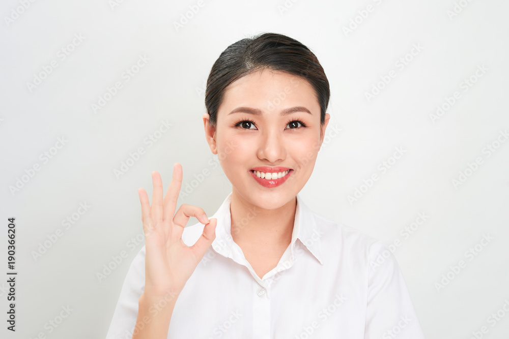 Beautiful asian woman smiling and showing OK sign . Presenting your product. Beautiful asian woman smiling and showing OK sign . Presenting your product.