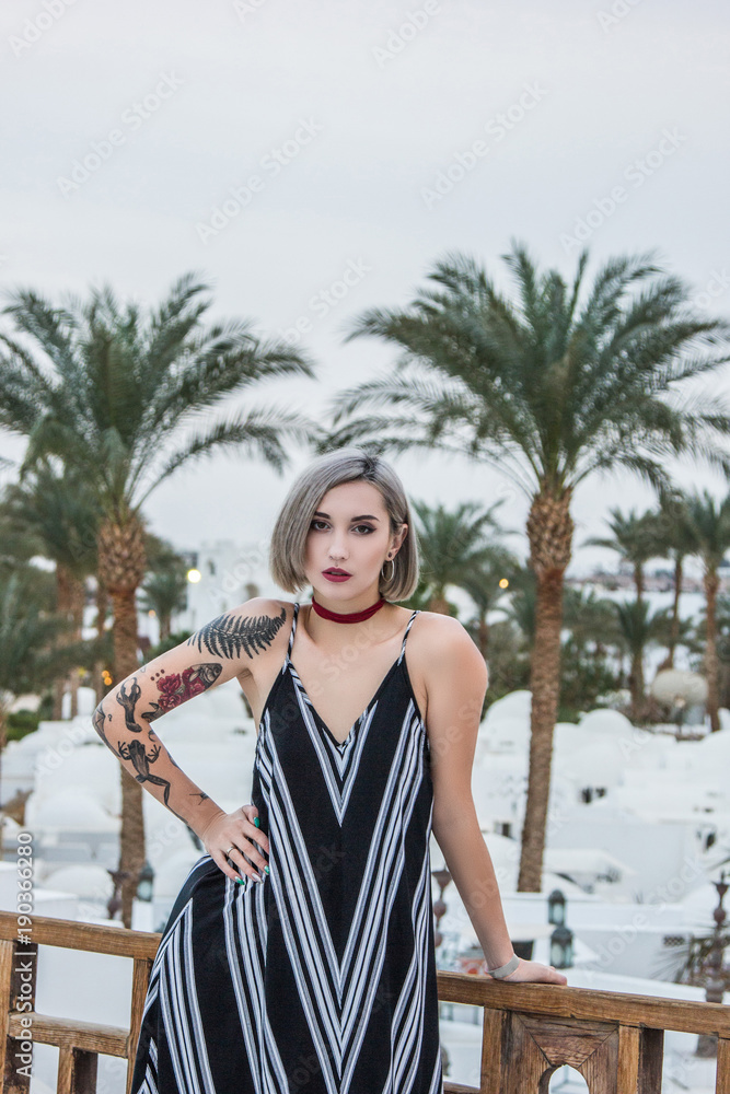 beautiful young woman standing with hand on hip and looking at camera at resort in Egypt