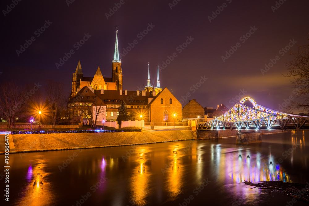 Holy Cross church and Odra river at night in the Wroclaw city, Silesia, Poland