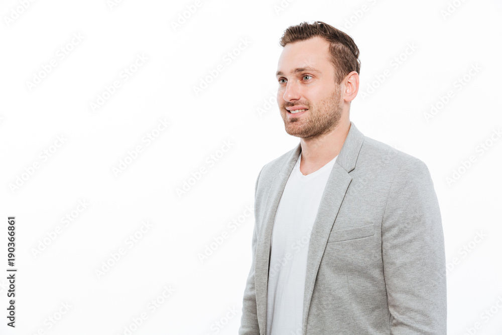 Portrait of businesslike guy in jacket having bristle posing on camera with smile and looking aside, isolated over white wall copy space Portrait of businesslike guy in jacket having bristle posing on camera with smile and looking aside, isolated over white wall copy space