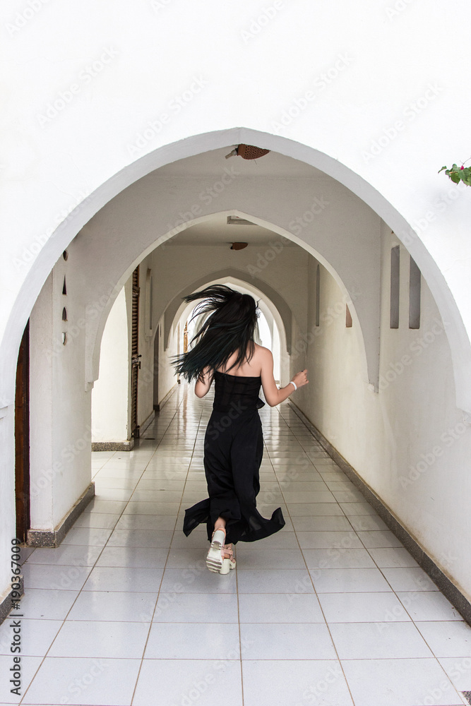 back view of young woman running at corridor back view of young woman running at corridor