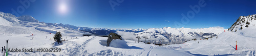 beautiful panoramic landscape on the slopes in  the snowy mountain under sunny blue sky © coco