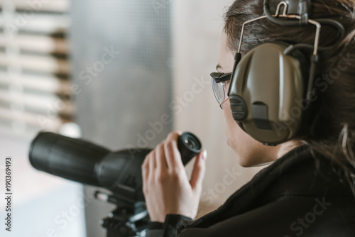 side view of woman with binoculars in shooting range