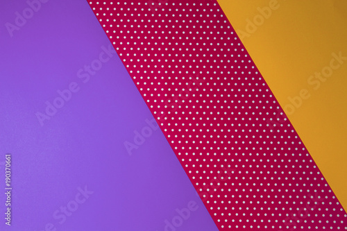 Abstract geometric yellow, purple and polka dot paper background.