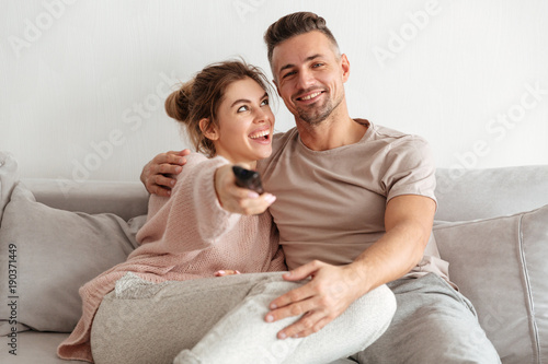 Portrait of a happy young couple sitting on a couch together