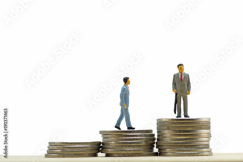 Miniature  business people on step of coin money