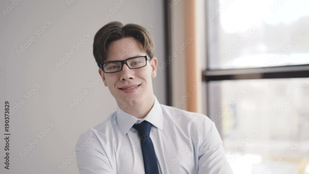 Handsome man speaking on the phone in office at window. 4K Handsome man speaking on the phone in office at window. 4K