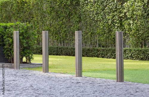 Photos stainless steel bollards on floor between road and green grass