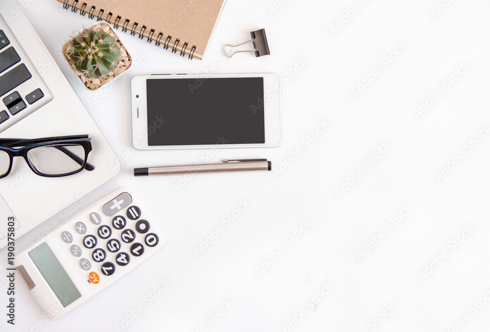 White office desk table, workspace office with laptop, smartphone black screen,pen,calculator, glasses, Top view with copy space White office desk table, workspace office with laptop, smartphone black screen,pen,calculator, glasses, Top view with copy space