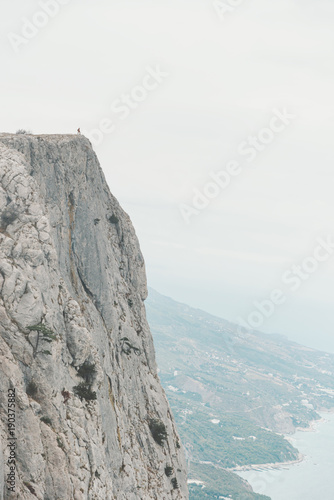 Small figure of man on edge of cliff.