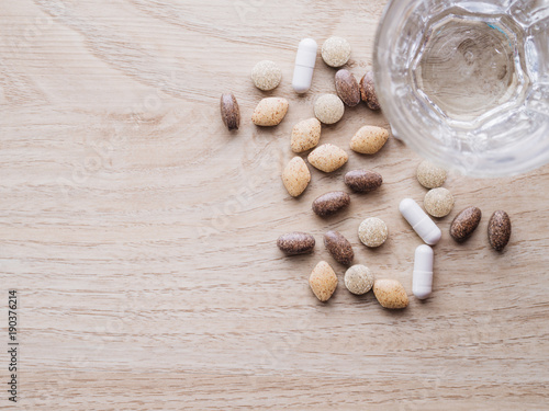 Many pill of vitamin and medicine with glass of water