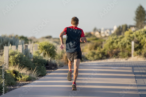 Fototapeta Naklejka Na Ścianę i Meble -  back portrait of young sport runner man with fit and strong healthy body training on off road track in Summer running workout