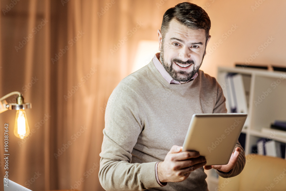 I like it. Cheerful brunette expressing positivity and holding tablet in both hands while chatting online I like it. Cheerful brunette expressing positivity and holding tablet in both hands while chatting online