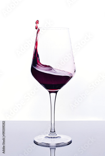 Copa de vino tinto sobre fondo blanco  photo