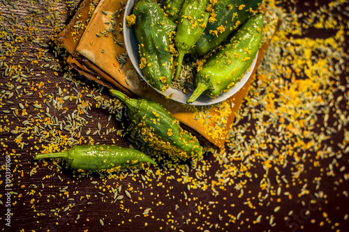 Green chilli pickle marinated in mustard seeds and mustard oil. Dark gothic style still life concept. photo
