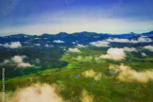 Kamchatka. Wild nature. Green fields and volcanoes. View from the helicopter.