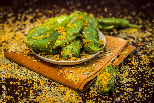 Green chilli pickle marinated in mustard seeds and mustard oil. Dark gothic style still life concept. photo