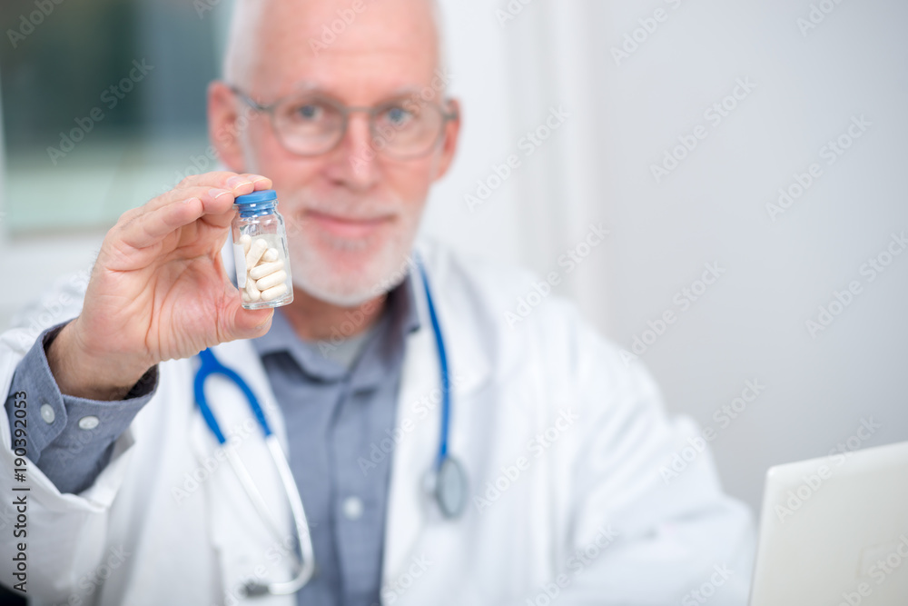 mature doctor with pill in hospital mature doctor with pill in hospital