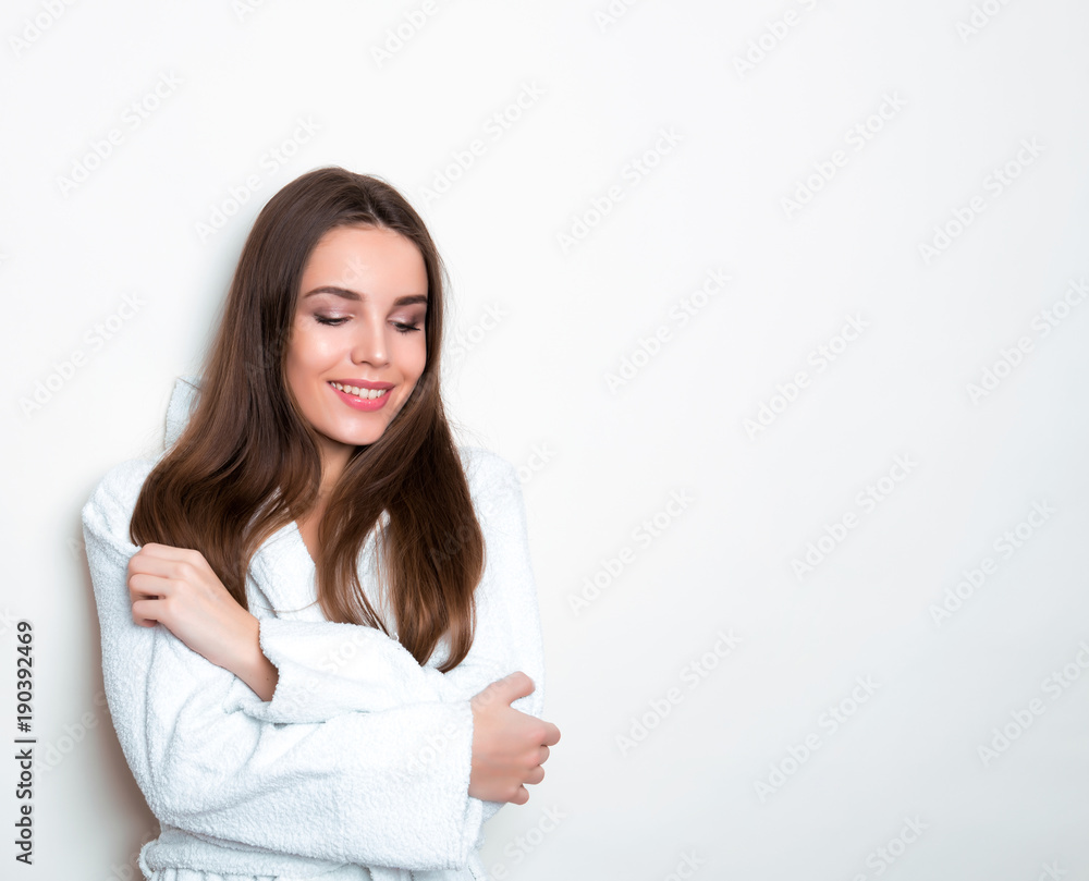 beautiful young woman wearing a bath robe and posing on background with copy space beautiful young woman wearing a bath robe and posing on background with copy space