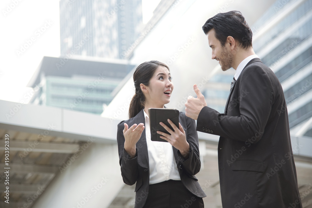 Businessman and businesswoman partner discussing while walking in office building. Businessman and businesswoman partner discussing while walking in office building.
