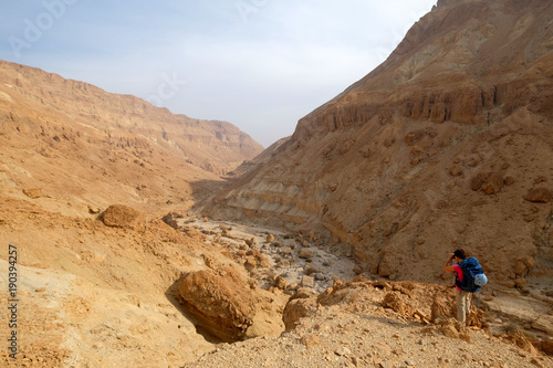 Alone hiker make photo of huge Zeelim gorge in Judea desert.