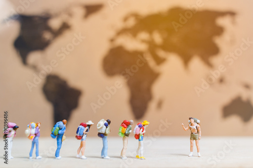 Miniature people travelers walking on world map ,