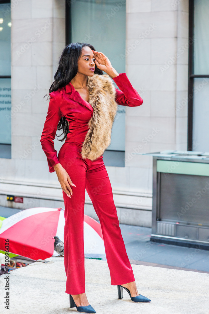 Fashion Woman in New York. Young African American Woman with long hair  dressing in red slim