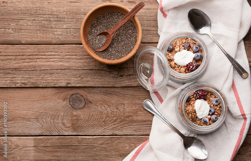 breakfast with chia, yoghurt and granola on a wooden table breakfast with chia, yoghurt and granola on a wooden table