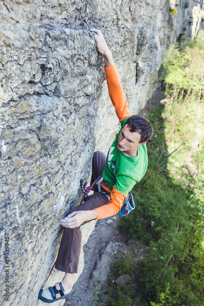 A rock climber on a rock. A rock climber on a rock.