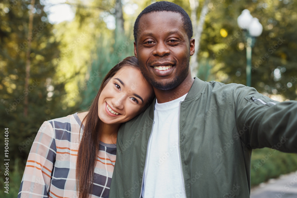 Fototapeta premium Young beautiful couple making selfie at park