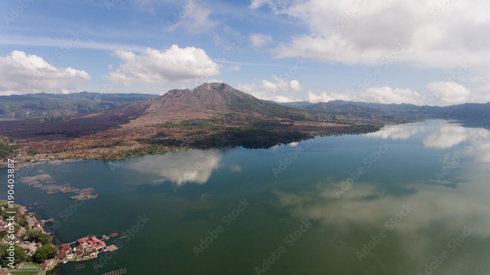 Aerial view Mountains, volcanoes, crater lake Batur, Bali, Indonesia. Mountain landscape with volcanoes, lake, sky and clouds. Travel concept