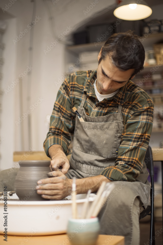 Artist makes clay pottery on a spin wheel Artist makes clay pottery on a spin wheel