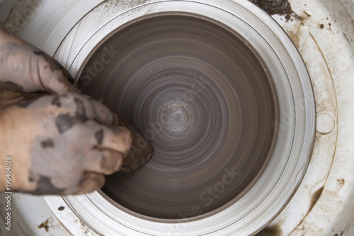 Fotografia, Obraz Artist makes clay pottery on a spin wheel