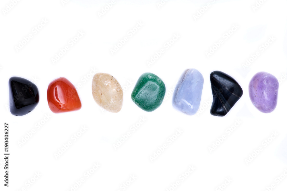 Set of seven healing chakra stones for crystal healing, isolated on white background Set of seven healing chakra stones for crystal healing, isolated on white background