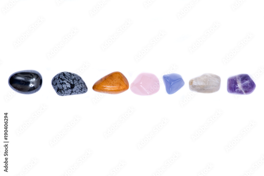 Set of seven healing chakra stones for crystal healing, isolated on white background Set of seven healing chakra stones for crystal healing, isolated on white background