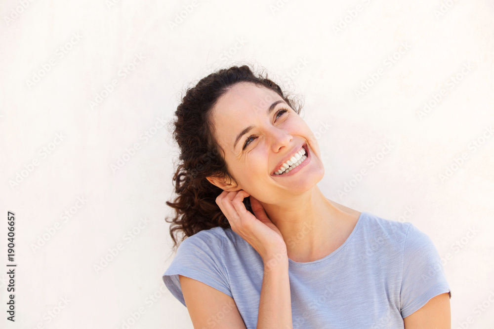 Horizontal portrait of young woman smiling against white wall Horizontal portrait of young woman smiling against white wall