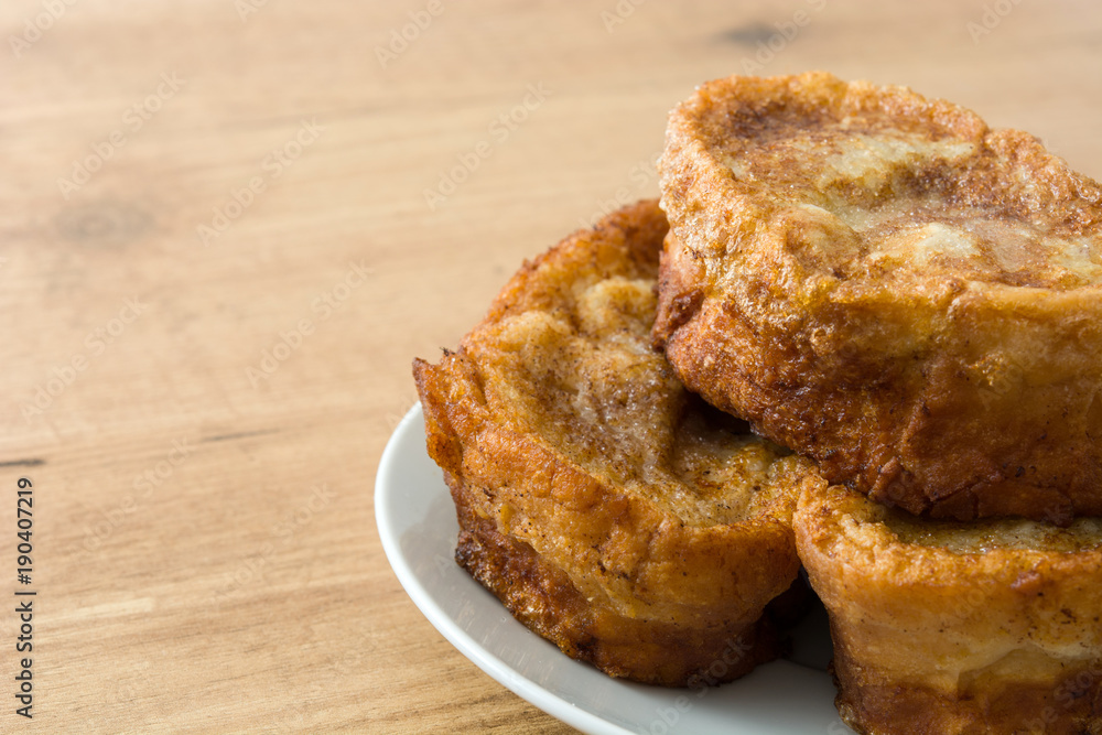 Traditional homemade Spanish torrijas on wooden background. Easter dessert. Traditional homemade Spanish torrijas on wooden background. Easter dessert.