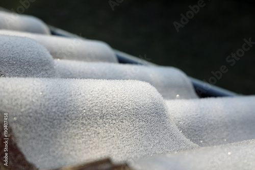 Frozen house roof covered by ice crystals