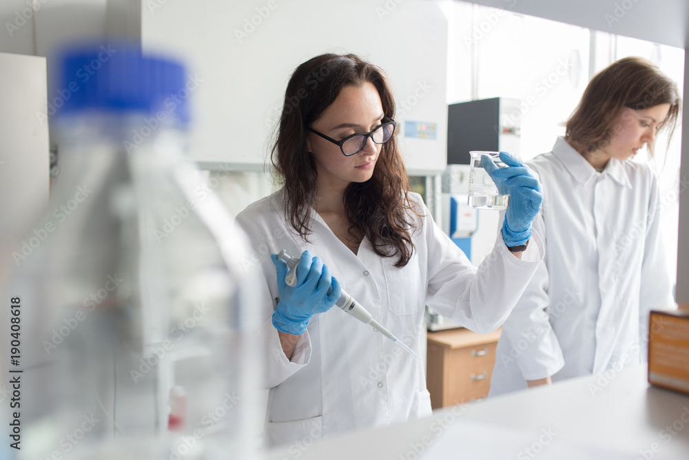 Woman holding flask in lab Woman holding flask in lab