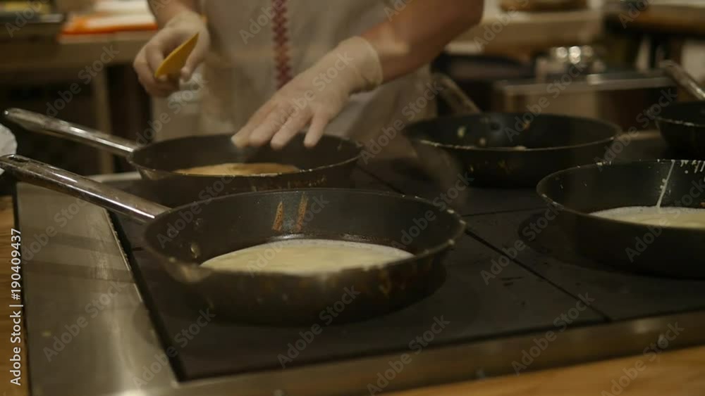 Hand With Special Tools Cooking Pancakes on the Plate Hand With Special Tools Cooking Pancakes on the Plate
