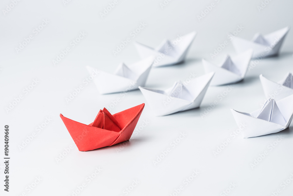 Leadership concept with red paper ship leading among white on white background. Leadership concept with red paper ship leading among white on white background.