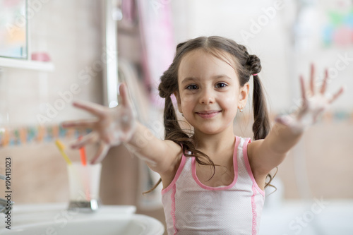 Kid washing hands and showi...