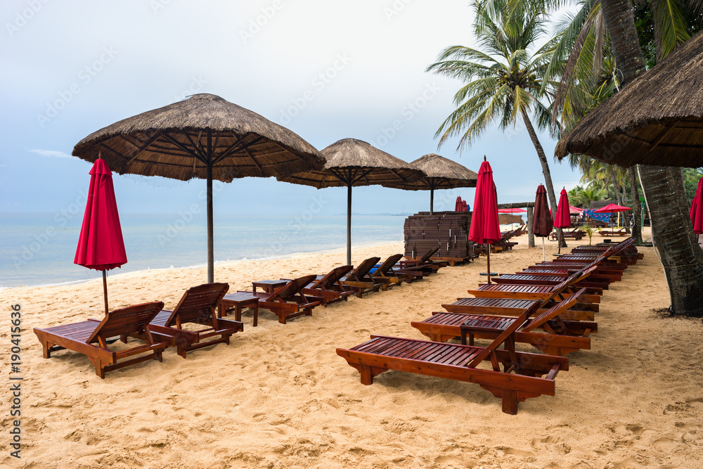Bad cloudy weather in wet low season on Phu Quoc island. Nobody on Long Beach. Empty sunbeds Bad cloudy weather in wet low season on Phu Quoc island. Nobody on Long Beach. Empty sunbeds