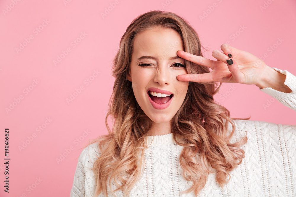 Cheerful young woman showing peace gesture. Cheerful young woman showing peace gesture.