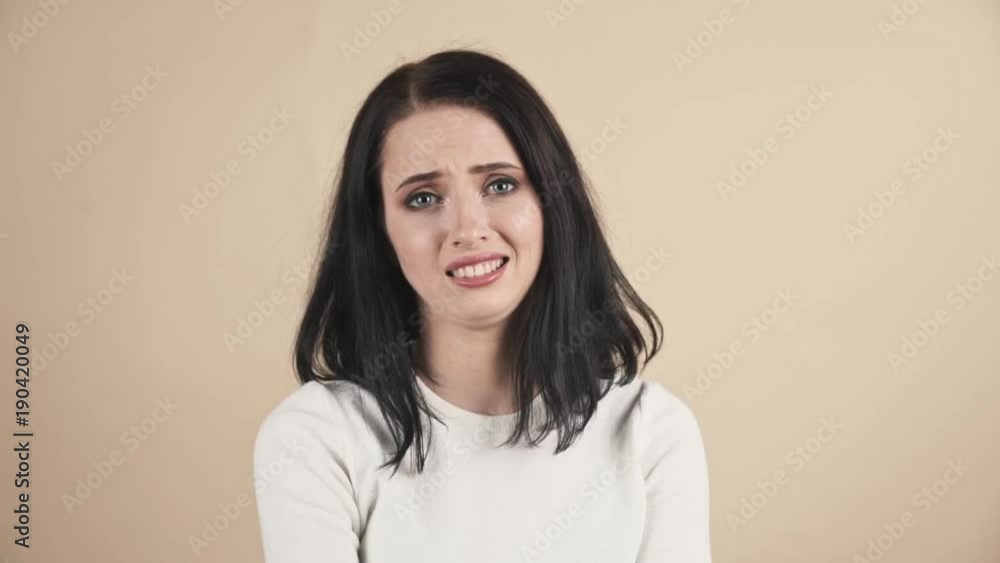 a young beautiful cute brunette on a beige orange background showing oops, Oh, accidentally, not guilty emotions a young beautiful cute brunette on a beige orange background showing oops, Oh, accidentally, not guilty emotions