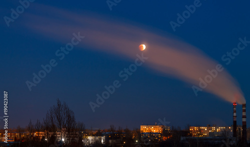 Lunar eclipse on January 31, 2018 on the background of a smoke plume. Eclipse, the super moon, the full moon. Western Siberia. At the peak of the eclipse.