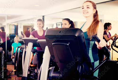 females training on elliptical trainers in fitness club