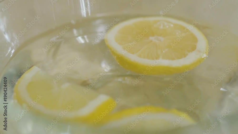 Lemon falls in slowmotion into a bowl with water Lemon falls in slowmotion into a bowl with water