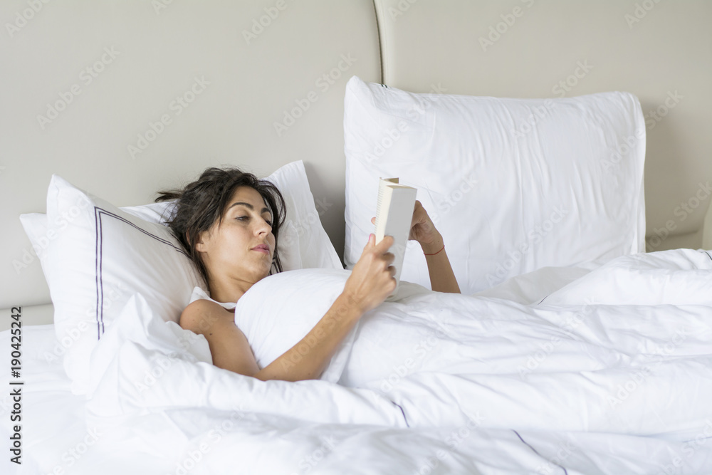 Beautiful Young Woman Reading Book in the Bed.Leisure Time Beautiful Young Woman Reading Book in the Bed.Leisure Time