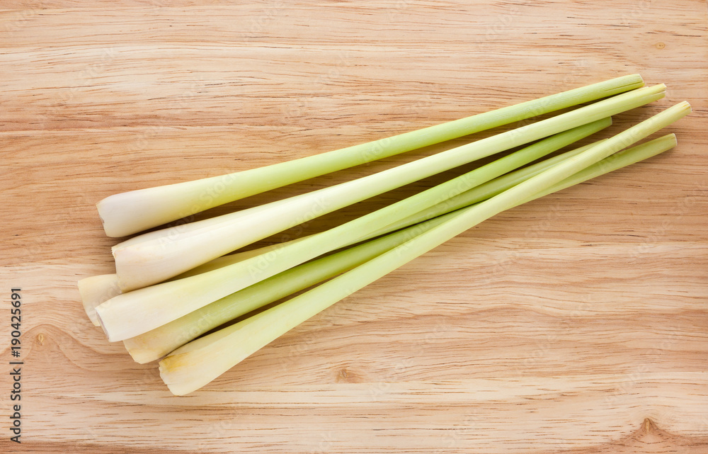 Lemongrass close-up on a wooden table. Fresh stems of lemongrass on a wooden surface. Lemongrass close-up on a wooden table. Fresh stems of lemongrass on a wooden surface.